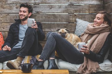 A man and woman enjoy a moment together with a dog.